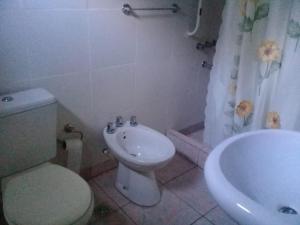 a bathroom with a toilet and a sink and a tub at La rana alquiler temporal in Reyes