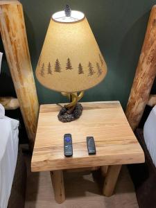 a lamp on a table with two remote controls at Cedar Mountain Suite E in Grants Pass