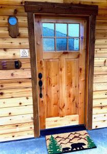 una puerta en una cabaña de madera con una alfombra delante en Cedar Mountain Suite E, en Grants Pass