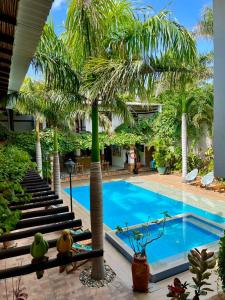 a swimming pool with palm trees next to a resort at Camali Hotel in Santa Marta