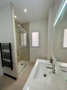 a white bathroom with a sink and a shower at Flores Paradise in Puerto de Sagunto