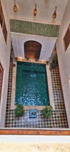 馬拉喀什的住宿－Riad Belikoss Pool & SPA，一座大型游泳池,位于一座铺有瓷砖地板的房屋内