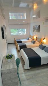 a hotel room with four beds and a table at Hotel Room 2 in Cali