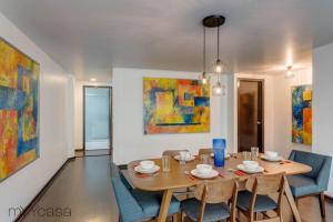 comedor con mesa, sillas y pinturas en Apartment in Quiet District, 8 min Walk from Masaryk, en Ciudad de México