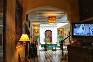 a hallway of a building with a television and a hallwayngthngthngthngthngth at Riad Belikoss Pool & SPA in Marrakech