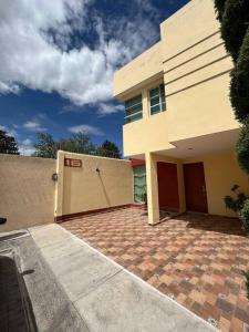 una casa con una entrada de ladrillo delante de ella en Casa llena de vida y estilo en un conjunto con vigilancia céntrico en Puebla, en Puebla