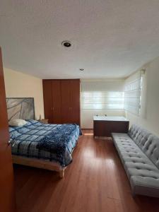 ein Schlafzimmer mit einem Bett und einem Sofa darin in der Unterkunft Casa llena de vida y estilo en un conjunto con vigilancia céntrico en Puebla in Puebla