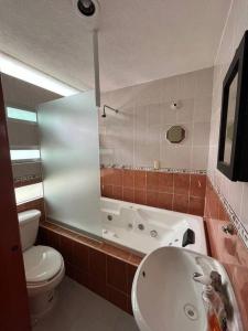 a bathroom with a toilet and a tub and a sink at Casa llena de vida y estilo en un conjunto con vigilancia céntrico en Puebla in Puebla