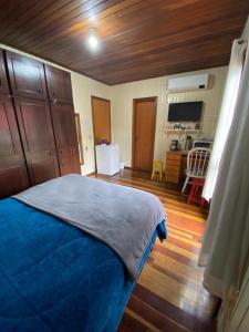 1 dormitorio con 1 cama azul y cocina en Suite 391 en Canela