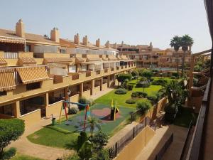 an apartment complex with a playground in the courtyard at Ático con gran terraza a 50 metros de la playa de Casares in San Luis de Sabinillas