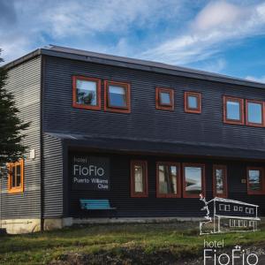 a black building with a bench in front of it at Hotel Fio Fio in Puerto Williams