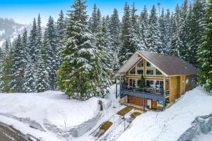 Snoqualmie Pass的住宿－Creek Run Lodge Entire Property，树前的雪覆盖的房子