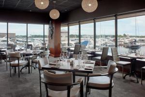 un restaurante con mesas y sillas y un puerto deportivo en Delta Hotels by Marriott Kingston Waterfront, en Kingston