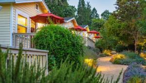 a row of houses with red umbrellas in a garden at Aurora Park Cottages in Calistoga