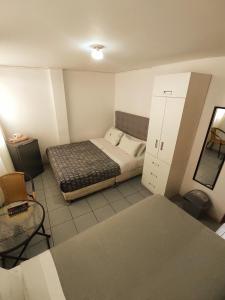 Habitación pequeña con cama y espejo. en Casita Libertad Chorrillos, en Lima