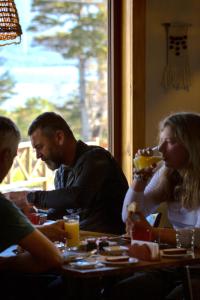 un grupo de personas sentadas en una mesa en un restaurante en Hotel Fio Fio, en Puerto Williams