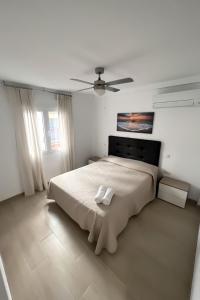 ein Schlafzimmer mit einem großen Bett und einem Deckenventilator in der Unterkunft Fantástico piso en Benidorm in Benidorm