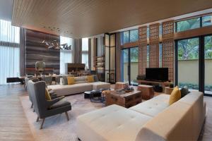 Il comprend un salon doté d'un mobilier blanc et d'une télévision. dans l'établissement Renaissance Xiamen Hotel, à Xiamen