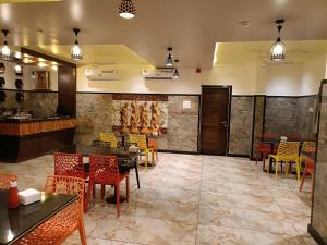 a restaurant with tables and chairs and a bar at Hotel Garuda Executive Latur in Lātūr