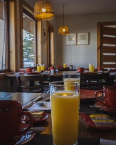 a glass of orange juice sitting on a table at Hotel Fio Fio in Puerto Williams