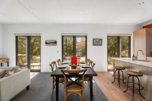 a kitchen and living room with a table and chairs at Gold Rush Chalet - Cardrona Holiday Home in Cardrona
