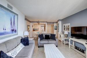 uma sala de estar com um sofá e uma mesa em St Regis 3302 em North Topsail Beach