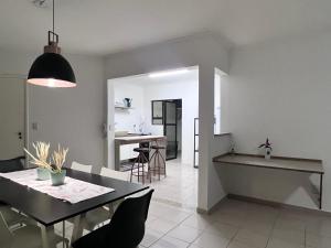 a kitchen and dining room with a dining table and a dining room at AeK apartamento conforto praia in Peruíbe