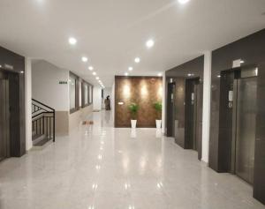 un couloir d'un immeuble avec ascenseurs et plantes dans l'établissement Ajith's Inn, à Kottayam