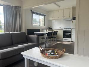 ein Wohnzimmer mit einem Sofa und einem Tisch in der Unterkunft Rivergum Holiday Park in Corowa