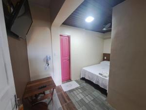 een kleine kamer met een bed en een rode deur bij Pousada Nova Ludovicense in São Luís