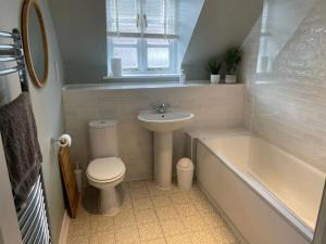 a bathroom with a toilet and a sink and a bath tub at New - Beautiful Countryside Home in Streatley