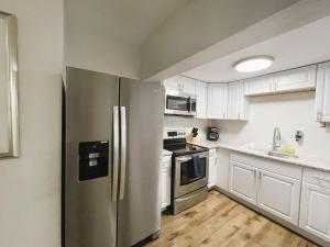 una cocina con nevera de acero inoxidable y armarios blancos en Spacious home in Tampa en Tampa