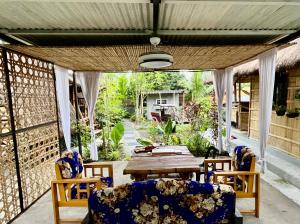 un patio con mesa de madera y sillas en Gensan Hostel, en General Santos