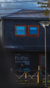 a black building with a sign in front of it at Hotel Fio Fio in Puerto Williams