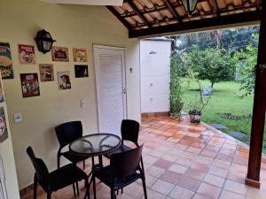 patio ze stołem, krzesłami i drzwiami w obiekcie Casa em Paraty - RJ Cond. Fechado w mieście Paraty