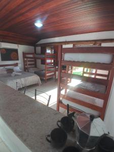 a room with two bunk beds and a counter at Suítes e Flats das Papoulas Ferradura In Búzios in Búzios