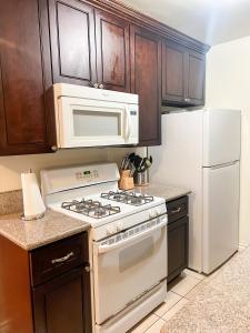 a kitchen with a white stove and a microwave at Centrally located UCLA Condo in Los Angeles