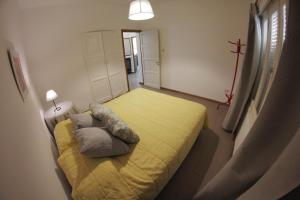 Habitación pequeña con cama y manta amarilla en La casita de mi infancia en Mendoza