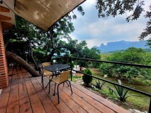 a wooden deck with a table and chairs on it at Amara Tepoztlán in Tepoztlán