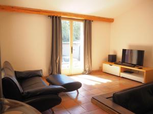 ein Wohnzimmer mit einem Sofa und einem TV in der Unterkunft Nice house with private pool in the Parc du Luberon, Grambois in Grambois
