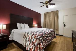 a hotel room with a bed and a ceiling fan at Red Roof Inn & Suites Statesboro - University in Statesboro