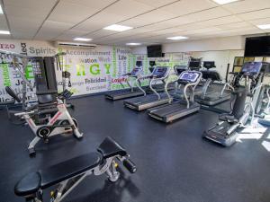 a gym with several treadms and cardio machines at Hotel Araiza Mexicali in Mexicali
