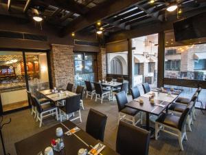 a restaurant with tables and chairs in a room at Hotel Araiza Mexicali in Mexicali