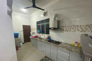 Il comprend une cuisine équipée d'un évier et d'un ventilateur de plafond. dans l'établissement Syikin Homestay - Private Pool, à Bedung