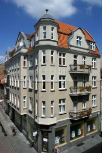 um grande edifício branco com um telhado vermelho em Hotel - Apartamenty Heban em Toruń