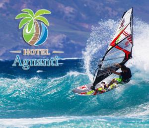 a man riding a wave on a surfboard in the ocean at Hotel Agnanti in Ágios Konstantínos