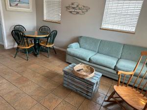 a living room with a couch and a table and chairs at Seaside bungalow in Daytona Beach
