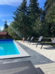 - une piscine avec des chaises longues et une table dans l'établissement Iglika Hotel Borovets, à Borovets