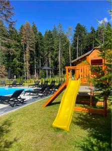 a playground with a slide next to a house at Iglika Hotel Borovets in Borovets