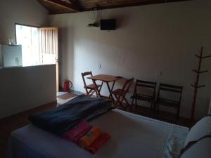 - une chambre avec un lit, une table et des chaises dans l'établissement Chalé Morada das estrelas, à Aiuruoca